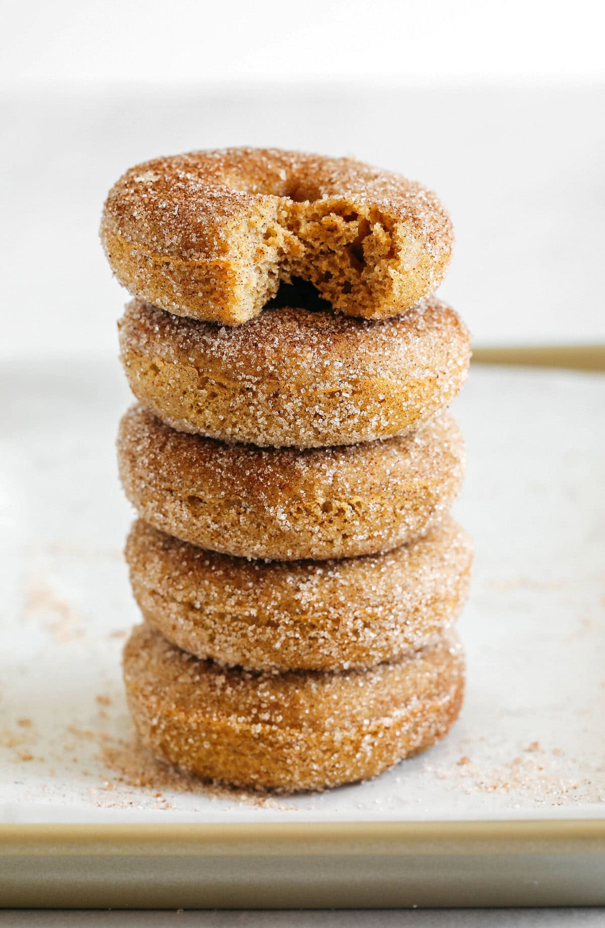 Soft Baked Apple Cider Donuts made healthier with whole wheat flour, applesauce and Greek yogurt for the perfect fall treat that comes together in just 20 minutes! Loaded with warm spices and coated with cinnamon and sugar!