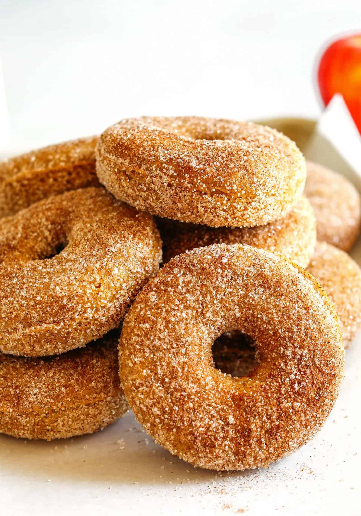 Soft Baked Apple Cider Donuts made healthier with whole wheat flour, applesauce and Greek yogurt for the perfect fall treat that comes together in just 20 minutes! Loaded with warm spices and coated with cinnamon and sugar!