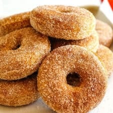 Soft Baked Apple Cider Donuts made healthier with whole wheat flour, applesauce and Greek yogurt for the perfect fall treat that comes together in just 20 minutes! Loaded with warm spices and coated with cinnamon and sugar!