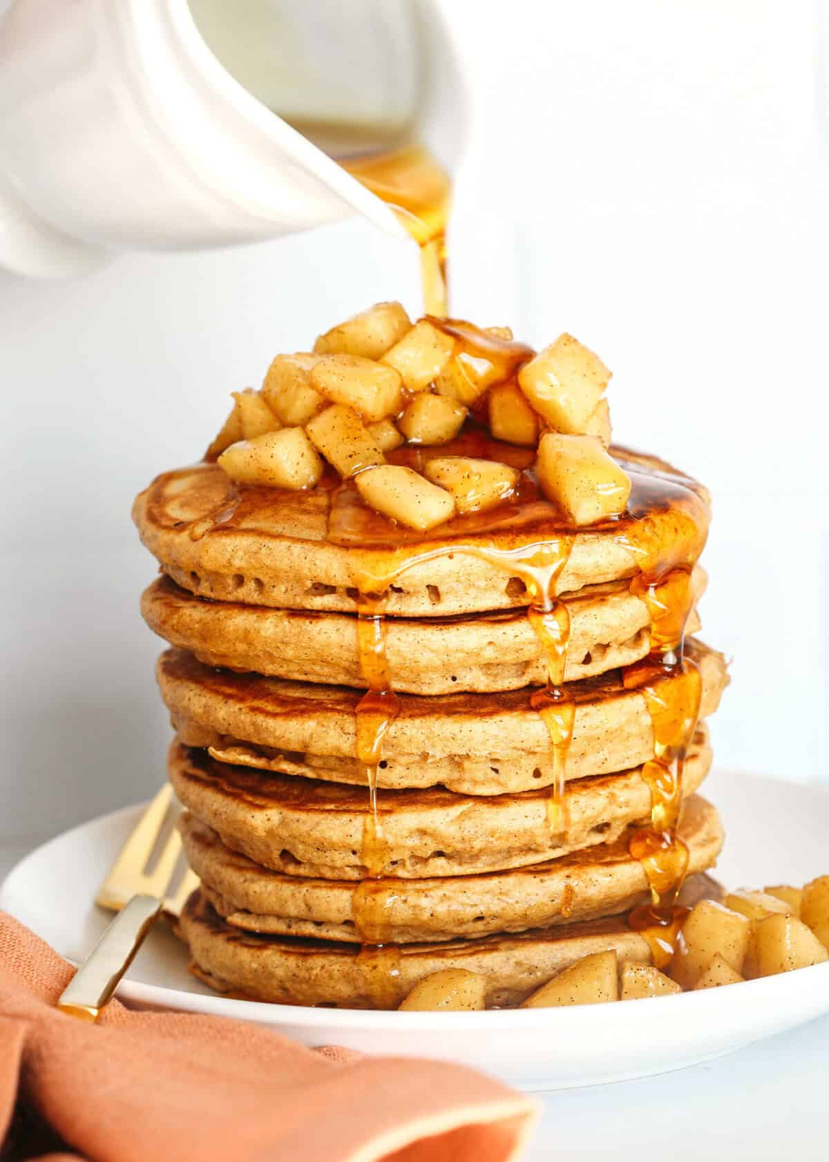 Light and fluffy Apple Cinnamon Pancakes made healthier with whole wheat flour, applesauce in place of oil and zero butter or refined sugar! Topped with warm spiced apples and drizzled with maple syrup!